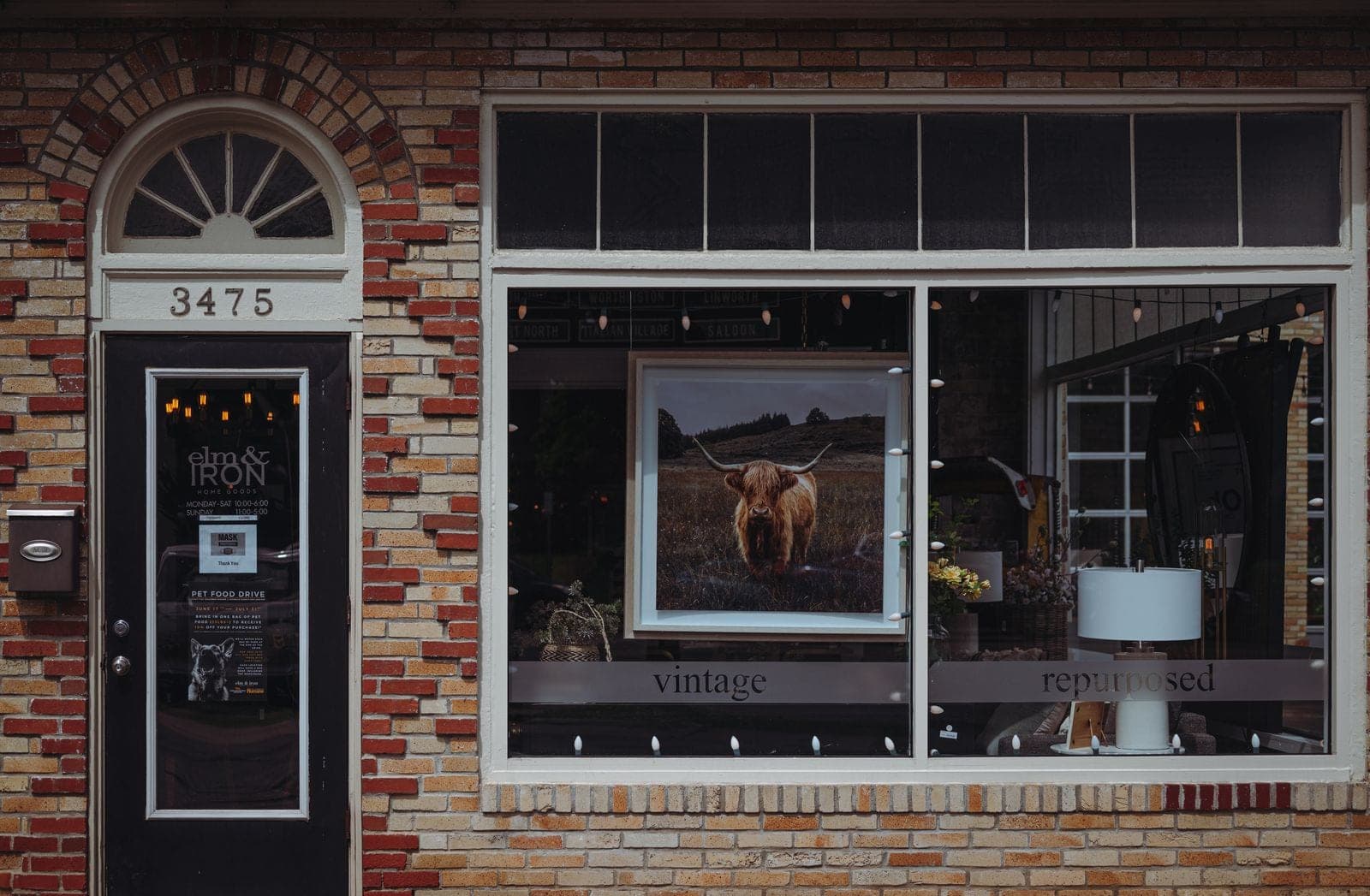 Brick storefront with an arched door and a large display window